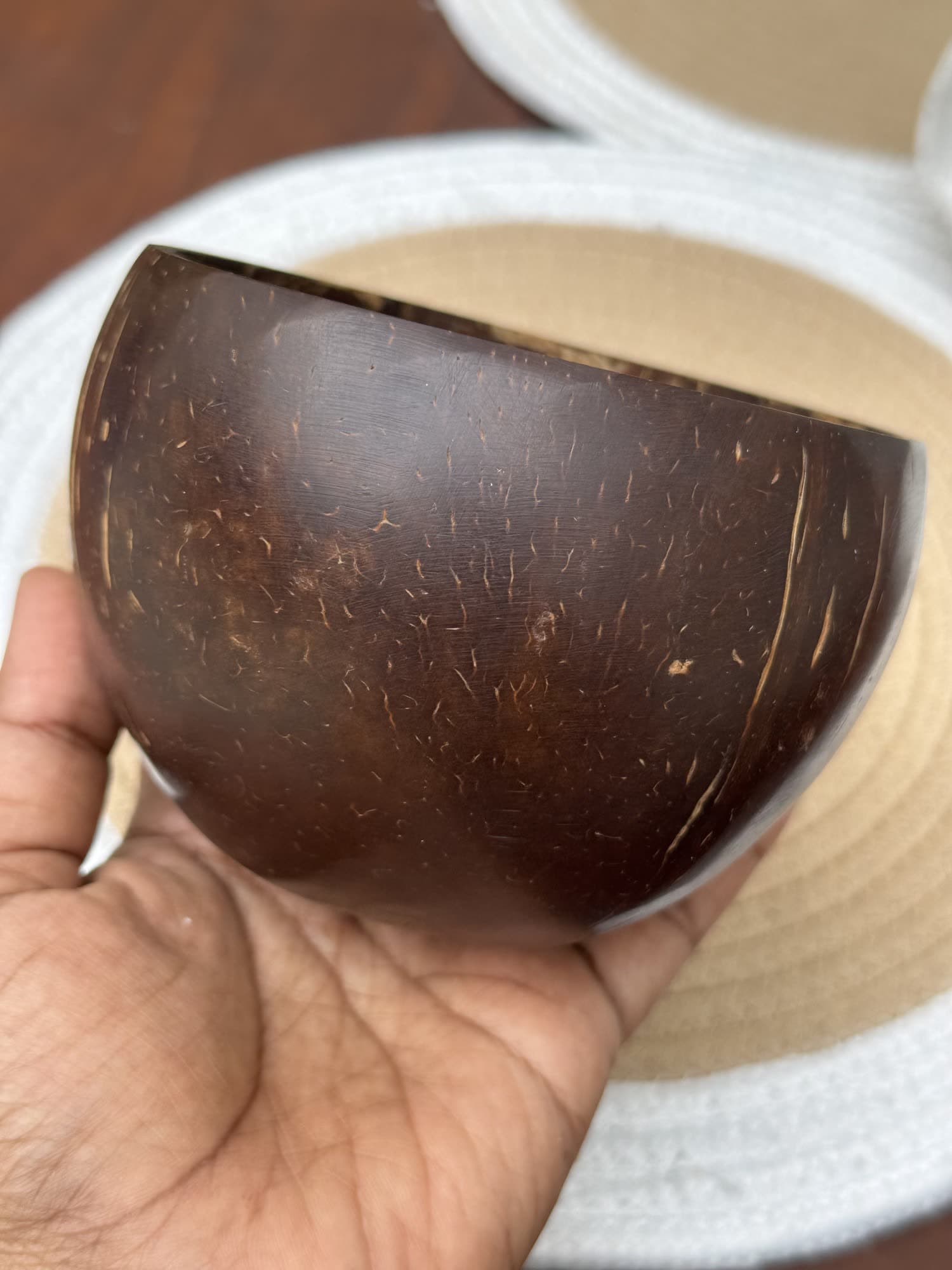 A polished coconut shell bowl held in one hand
