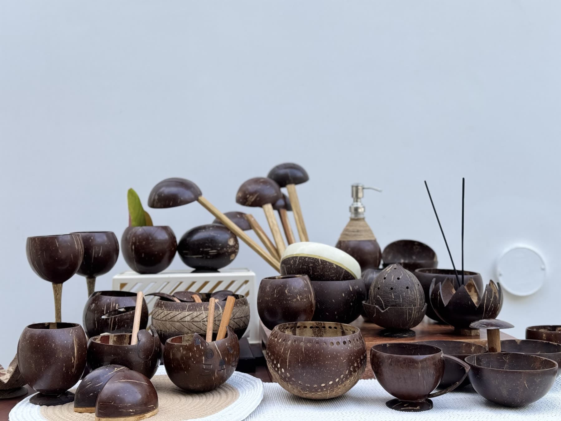 The Thenga Story range: coconut shell bowls, cups, ladles, a lantern and a soap dispenser on one table